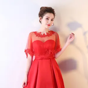 Vue détaillée de l'élégante cape en dentelle rouge et de la robe de soirée de mariée.