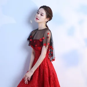 Elegante mantellina scialle in pizzo floreale nero trasparente abbinata a abito rosso da sera.