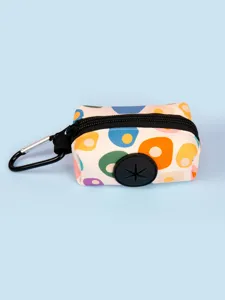 Close-up of portable dog poop bag dispenser pouch with colorful abstract pattern and carabiner.