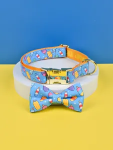 Nahaufnahme von Haustier Halsband und Fliege Set mit Eiscreme Muster und goldener Metallbeschlag.