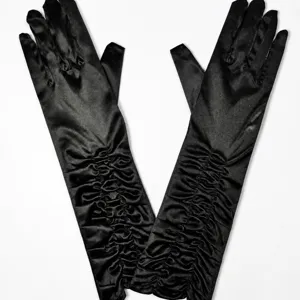 Black satin gathered long gloves detail view, elegant evening party and wedding costume accessory.