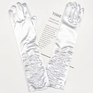 Detail shot of white satin pleated long gloves, elegant bridal accessory for wedding and evening.
