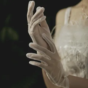 Detail view of white sheer short bridal gloves featuring elegant pearl accent for wedding.