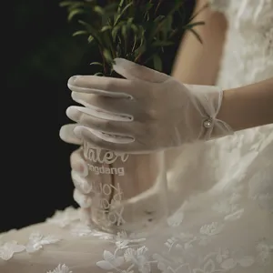 Bridal sheer white short gloves with delicate pearl wrist detail for wedding photo shoot elegant style