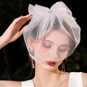 Short bridal veil with bow and rhinestones, elegant wedding hair accessory for brides.