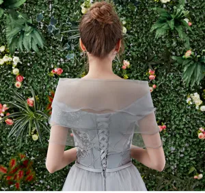 Detail shot of the elegant grey off-the-shoulder wedding shawl with lace embroidery.