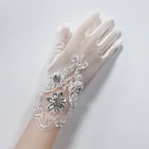 Guanti da sposa in pizzo a rete bianco con strass scintillanti per fotografia di matrimonio