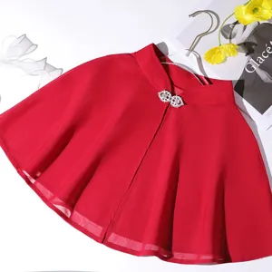 Detail shot of the elegant red chiffon cape shawl with dazzling rhinestone buckle for detail.