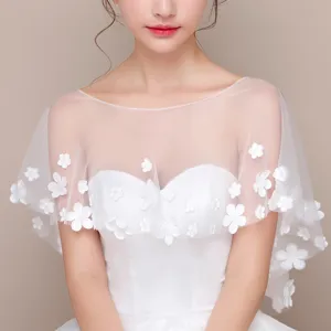 Dettaglio mantellina in tulle floreale bianco, elegante scialle da sposa per abito, leggero.
