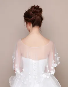 Vista dettagliata della mantellina da sposa bianca trasparente con delicato pizzo floreale.