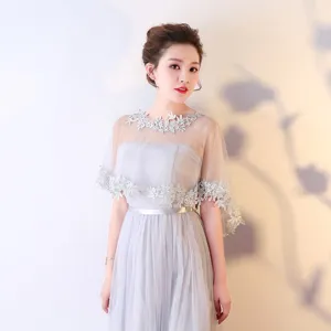 Détail élégant de robe cape en dentelle grise, idéal pour soirées et mariages d'été.