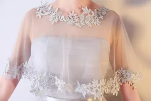 Vue détaillée de la cape de mariée transparente avec une élégante broderie en dentelle.