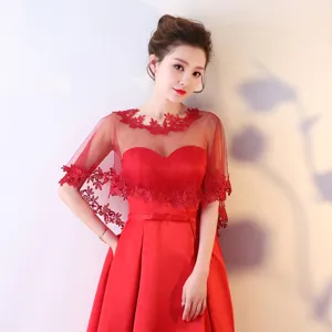 Détail de cape de mariée en dentelle rouge, élégant châle de robe de soirée transparent.