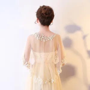 Vue détaillée de la cape de mariée en dentelle avec broderie florale délicate et un joli tombé.