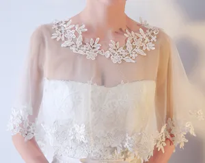 Détail de cape de mariée en dentelle blanche, châle en tulle transparent pour robe.