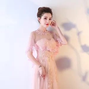Gros plan sur la cape de mariée en dentelle rose, broderie florale délicate et tissu en tulle.