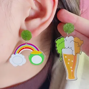 Primer plano detalle de pendientes acrílicos de San Patricio con arco iris y cerveza.