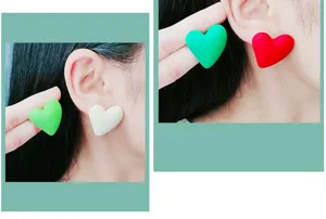 Vista dettagliata di orecchini a cuore in acrilico di tendenza indossati all'orecchio.