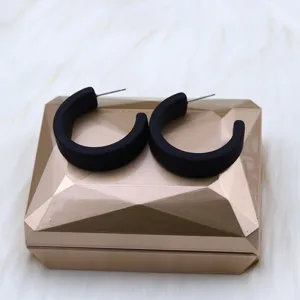 Detailed shot of matte black minimalist geometric C-hoop earrings, modern style accessory.