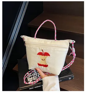 Cute Japanese style nylon crossbody bag with embroidered apple pattern and colorful braided straps.