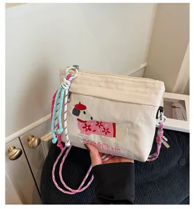 Mini-Leinwand Schulter-Umhängetasche mit süßem besticktem Dackel-Design und bunte Riemen.