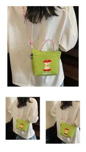 Green nylon shoulder crossbody bag featuring cute apple core embroidery and colorful braided strap.