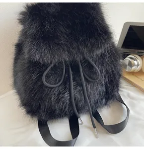 Black plush faux fur backpack detail shot showing soft texture, drawstring closure and straps.