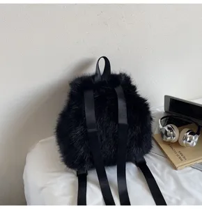 Detail view of a stylish black faux fur backpack with black webbing straps in cozy setup.