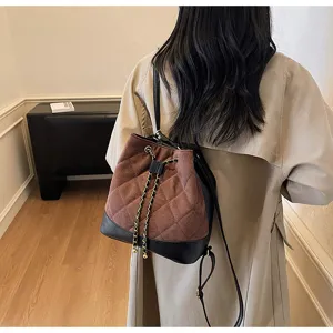 Vista dettagliata di un elegante zaino a secchiello in camoscio trapuntato con coulisse.