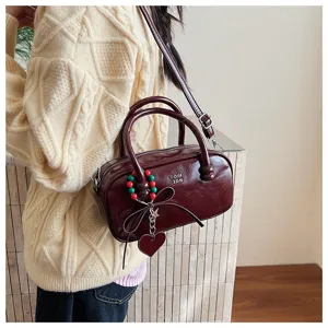 Retrorot Lackleder Bowling Handtasche mit Herzanhänger und Schultergurt für den Alltag.