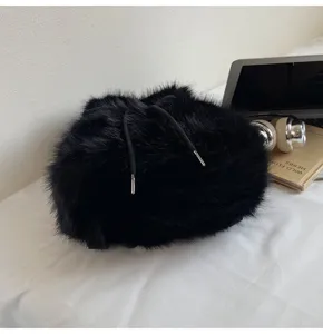 Close-up detail of a black fluffy plush drawstring backpack, cozy winter casual style.