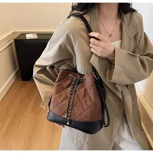 Elegante borsa a secchiello trapuntata da donna con coulisse a catena per uso quotidiano.