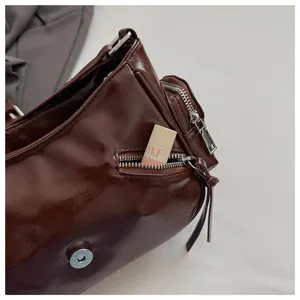 Brown oil wax leather motorcycle underarm bag detail view showing zipper pocket hardware.