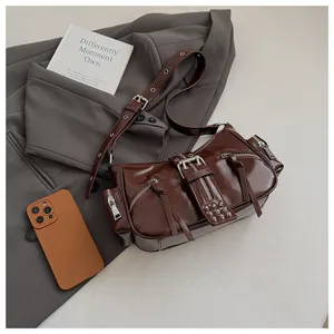 Dark brown patent leather motorcycle shoulder bag with zippers, metal buckles, and stylish rivets.