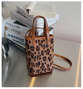 Primo piano dettagliato della borsetta a tracolla leopardata con eleganti manici in pelle.