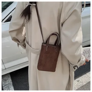 Vista dettagliata di una mini borsa a tracolla in camoscio marrone con trench.
