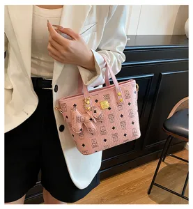 Pink leather bucket bag detail view, stylish tote handbag with chic monogram pattern design.