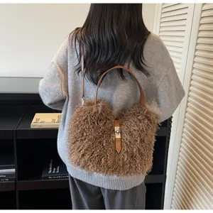 Chic plush brown shoulder bag with leather handle, cozy winter accessory detail view.