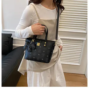 Trendy black bucket bag featuring monogram pattern, top handle, and crossbody strap.