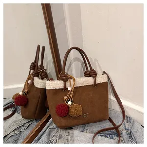 Detailansicht der Damen Herbst Winter Wildleder Handtasche mit Plüschfell und niedlichen Bommeln.