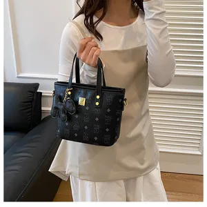 Black bucket bag for women, stylish top handle crossbody bag with trendy monogram design.