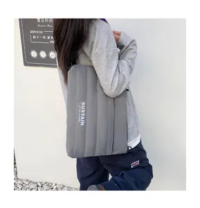 Graue gepolsterte 14-Zoll Laptop-Tasche im Detail, zeigt weiche Stepptextur und Gurt.