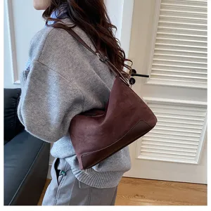 Detailansicht der dunkelbraunen Wildleder-Achseltasche mit hochwertigem Patchwork-Design und Textur.