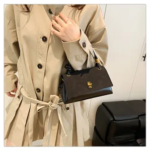 Chic suede patch handbag detail shot, featuring retro design with stylish gold lock closure.
