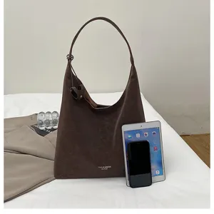 Detailansicht der retro braunen Wildleder-Schultertasche, lässiges Design für Pendler.