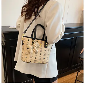 Stylish women bucket bag with shoulder strap and cute dog pendant monogram design.