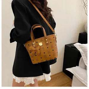 Stylish brown bucket shoulder bag for women, trendy leather handbag with cute bear pendant.