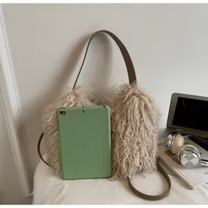 Fluffy faux fur shoulder bag detail view, soft curly texture and brown leather strap.
