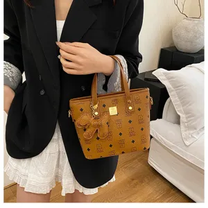 Chic brown monogram tote bucket bag for women, stylish leather shoulder handbag with cute charm.