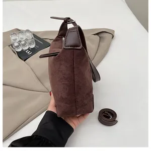 Detailaufnahme der braunen Wildleder-Achseltasche zeigt Textur, Reißverschluss und Lederdetails.